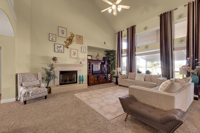 living room featuring light colored carpet, high vaulted ceiling, ceiling fan, and a tiled fireplace