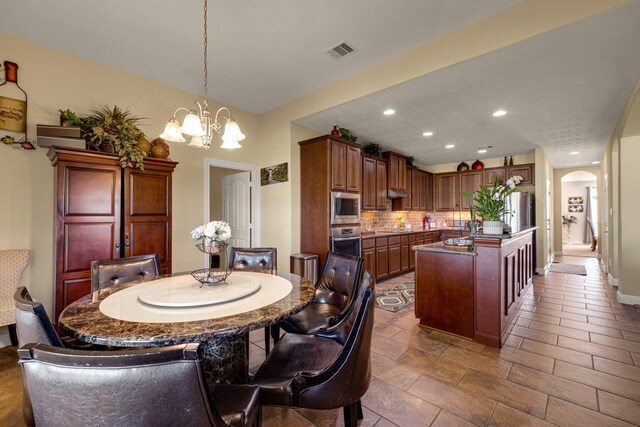 11411 Kings Point Blvd, Mont Belvieu, TX 77535 - dining room with arched walkways, a chandelier, and recessed lighting