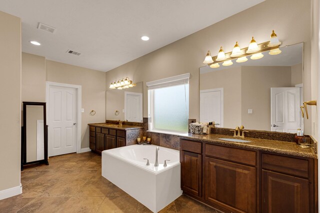 11411 Kings Point Blvd, Mont Belvieu, TX 77535 - bathroom with two vanities, a bath, and recessed lighting