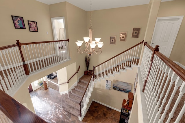 stairway with a high ceiling and an inviting chandelier