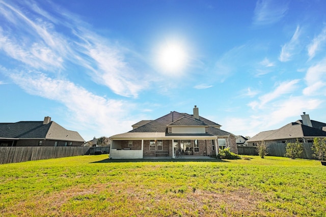 back of house with a yard and a patio