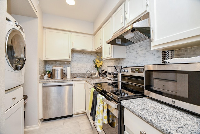 kitchen with white cabinetry, sink, tasteful backsplash, stacked washer and clothes dryer, and appliances with stainless steel finishes