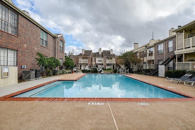 view of pool featuring a patio area and central AC unit