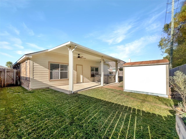 back of property featuring a lawn, ceiling fan, and a patio area