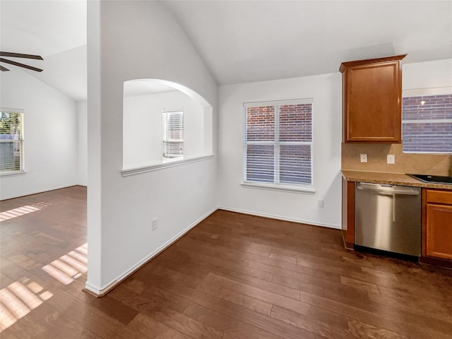 kitchen with ceiling fan, dark wood-type flooring, light stone counters, stainless steel dishwasher, and lofted ceiling