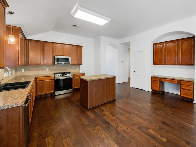 kitchen featuring pendant lighting, a center island, sink, dark hardwood / wood-style floors, and stainless steel appliances