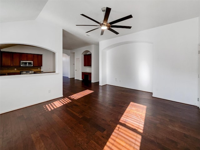 unfurnished living room with lofted ceiling, ceiling fan, and dark wood-type flooring