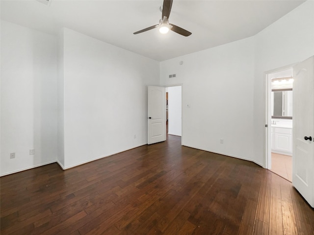 unfurnished bedroom featuring dark hardwood / wood-style floors, ensuite bath, and ceiling fan