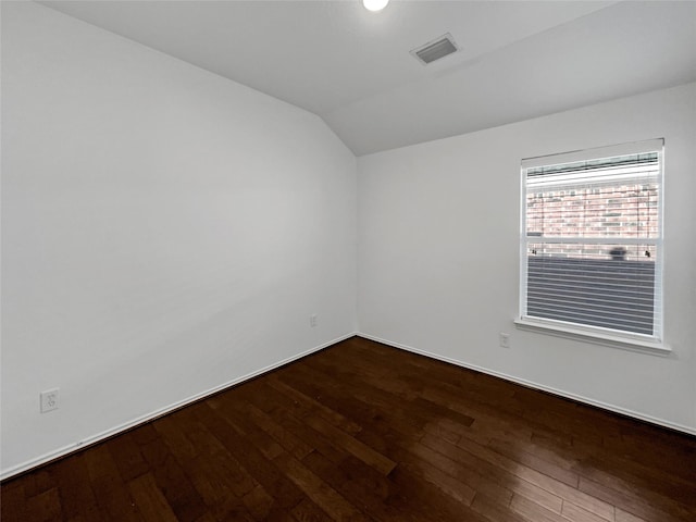 spare room with hardwood / wood-style flooring and lofted ceiling