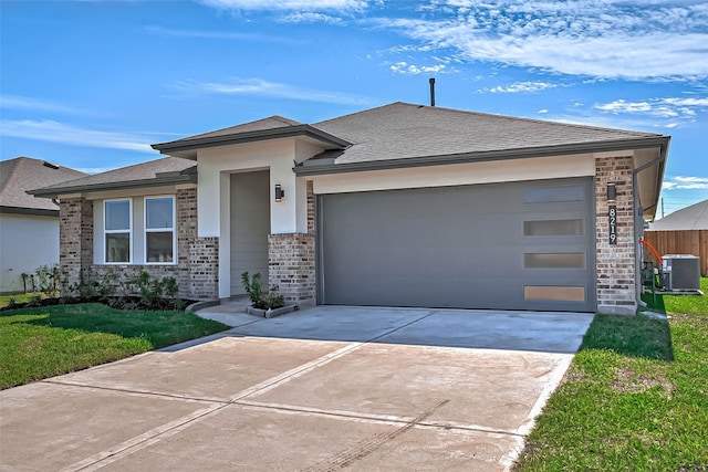 prairie-style home featuring a front lawn, a garage, and cooling unit