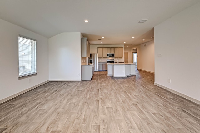 kitchen with appliances with stainless steel finishes, a center island, light hardwood / wood-style floors, and sink