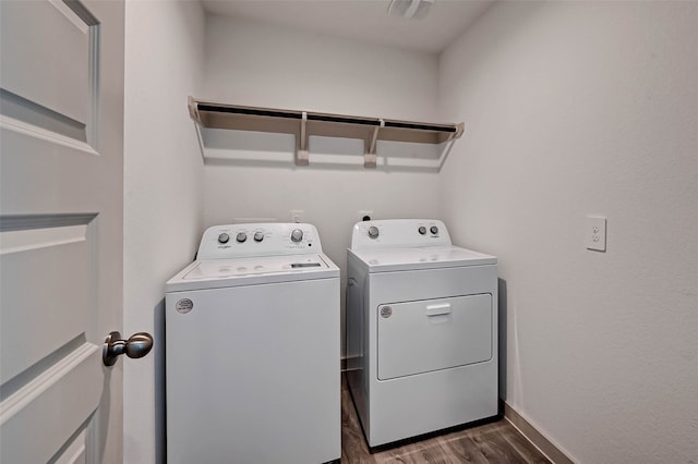 washroom with dark hardwood / wood-style flooring and washing machine and dryer