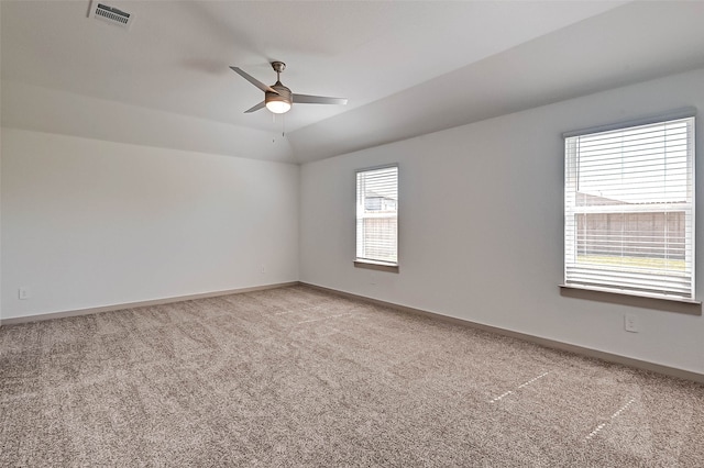 carpeted empty room featuring vaulted ceiling and ceiling fan