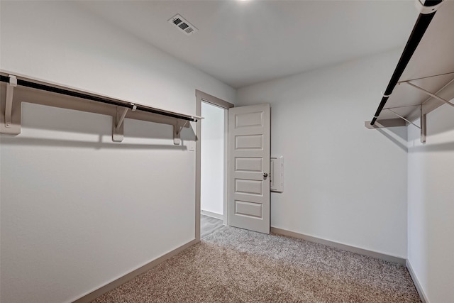 walk in closet featuring light colored carpet