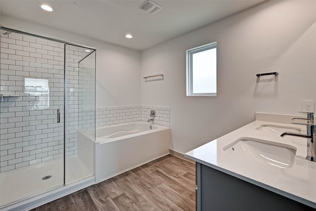 bathroom with wood-type flooring, vanity, and separate shower and tub