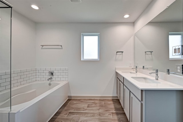 bathroom with a bathtub, vanity, and wood-type flooring