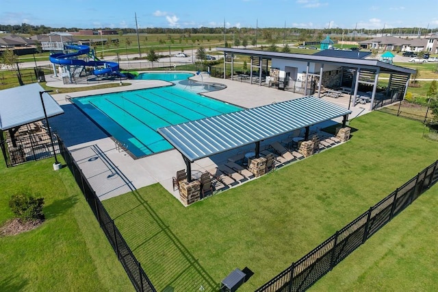 view of swimming pool with a patio area, a yard, and a water slide