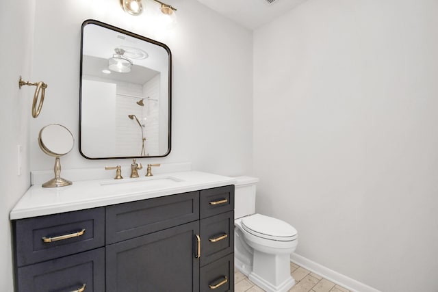 bathroom featuring vanity, toilet, and a shower