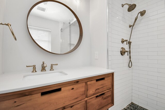 bathroom with vanity and tiled shower