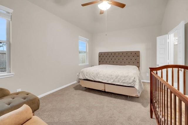 carpeted bedroom featuring multiple windows, lofted ceiling, and ceiling fan