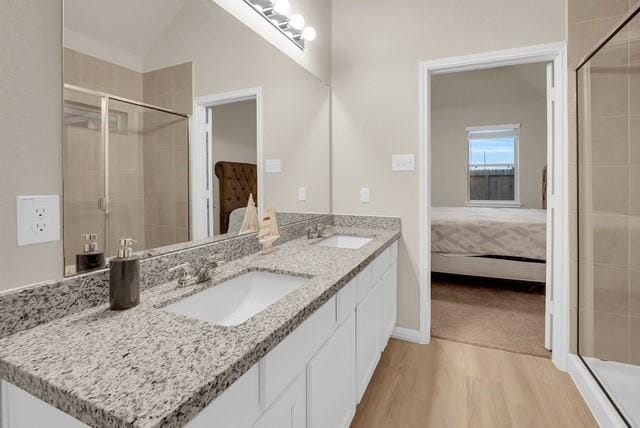 bathroom featuring hardwood / wood-style floors, vanity, lofted ceiling, and walk in shower