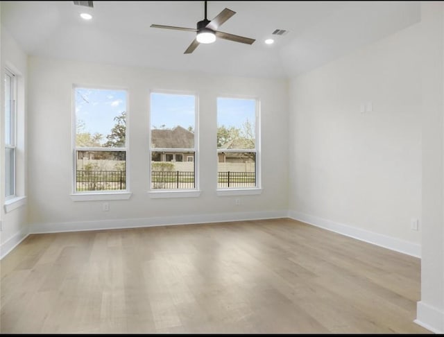 unfurnished room with light hardwood / wood-style flooring, a wealth of natural light, lofted ceiling, and ceiling fan