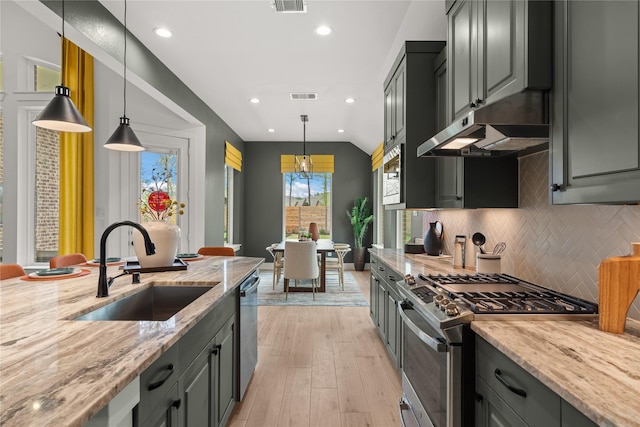 kitchen with light stone countertops, stainless steel appliances, gray cabinetry, and sink