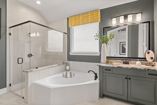 bathroom featuring vanity, shower with separate bathtub, and vaulted ceiling