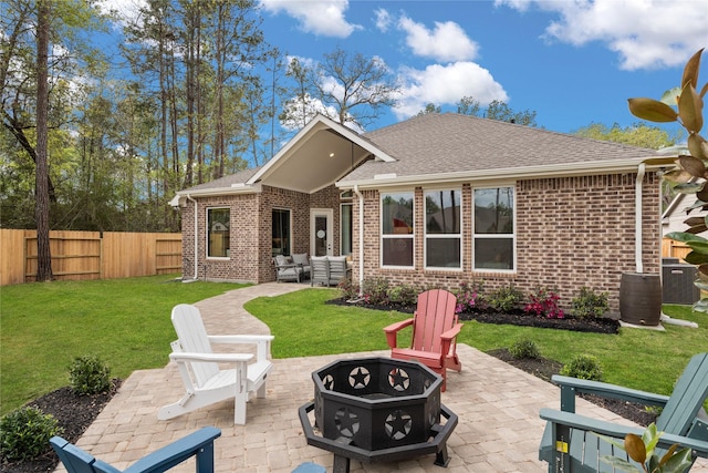 rear view of property featuring a patio, an outdoor living space with a fire pit, and a lawn