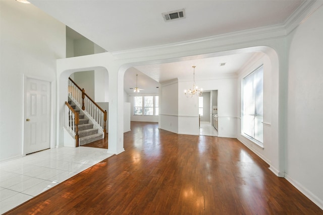 spare room with ceiling fan with notable chandelier, light wood-type flooring, and crown molding