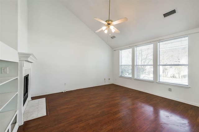 unfurnished living room featuring a tile fireplace, ceiling fan, high vaulted ceiling, and dark wood-type flooring