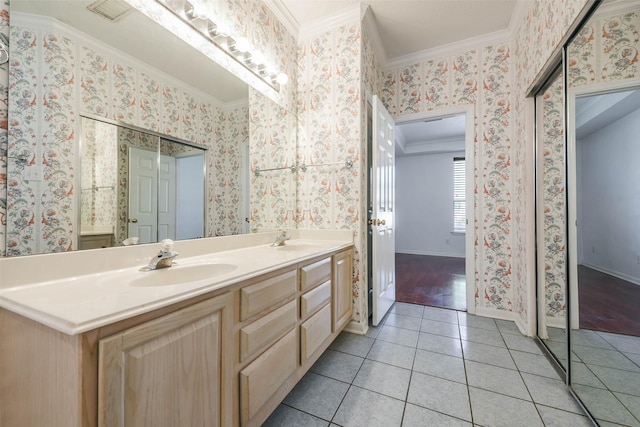 bathroom featuring tile patterned flooring, vanity, and crown molding