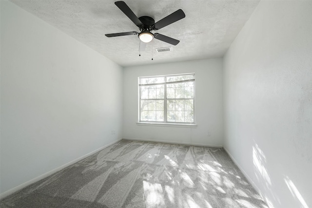 empty room featuring a textured ceiling, ceiling fan, and light carpet