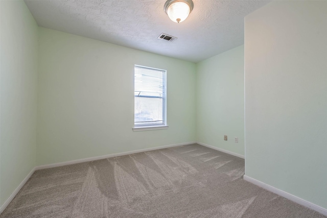 carpeted spare room with a textured ceiling