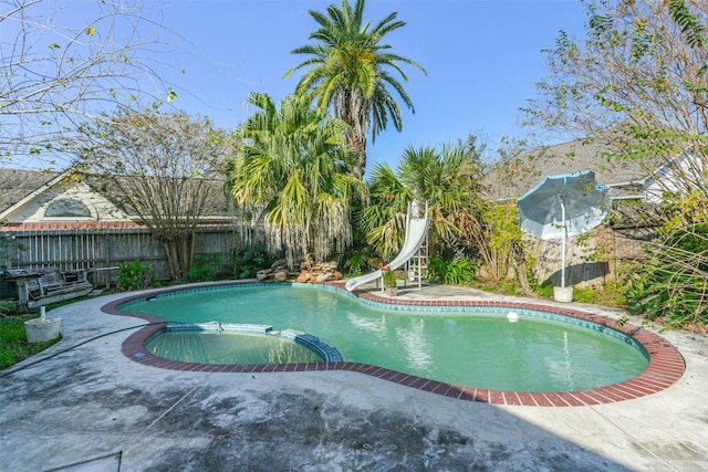 view of pool with an in ground hot tub, a patio, and a water slide