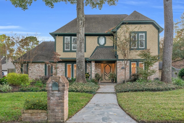 tudor home with a front lawn