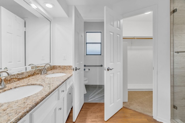 bathroom with vanity, hardwood / wood-style floors, toilet, and an enclosed shower