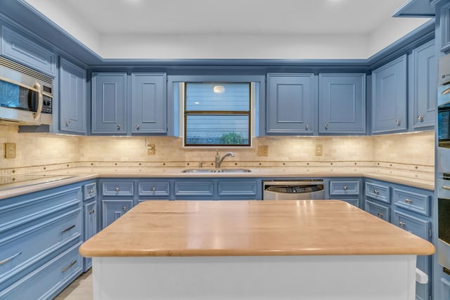 kitchen with stainless steel appliances, sink, and blue cabinets