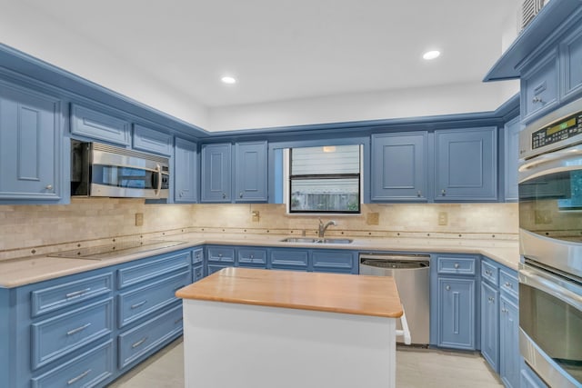 kitchen featuring sink, blue cabinetry, wooden counters, stainless steel appliances, and a center island