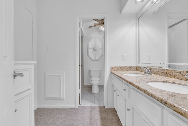 bathroom with tile patterned flooring, vanity, ceiling fan, and toilet