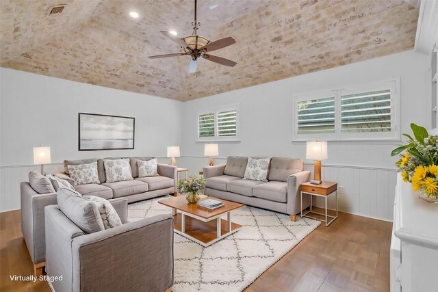 living room featuring parquet flooring, ceiling fan, and vaulted ceiling