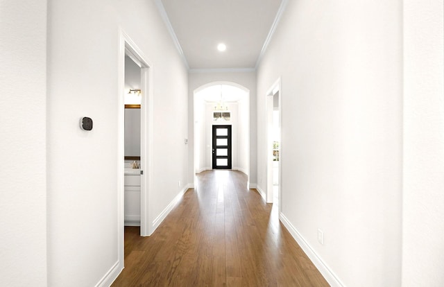hall with crown molding, baseboards, dark wood-style floors, recessed lighting, and arched walkways