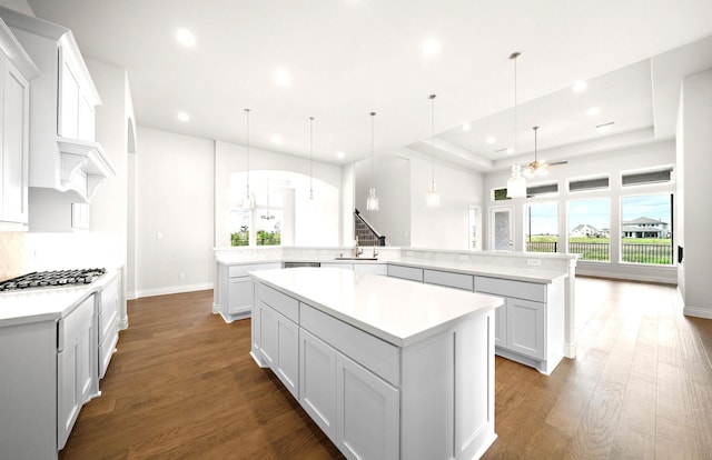 kitchen with recessed lighting, a large island with sink, stainless steel gas stovetop, and wood finished floors