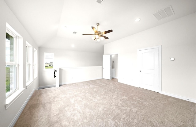 interior space featuring carpet floors, baseboards, visible vents, and lofted ceiling