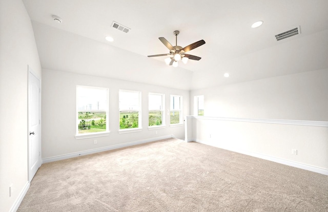 spare room with carpet flooring, a ceiling fan, baseboards, vaulted ceiling, and visible vents