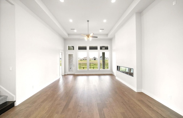 unfurnished living room featuring a ceiling fan, recessed lighting, wood finished floors, and stairway