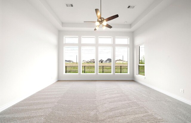 unfurnished room featuring plenty of natural light, carpet, and visible vents