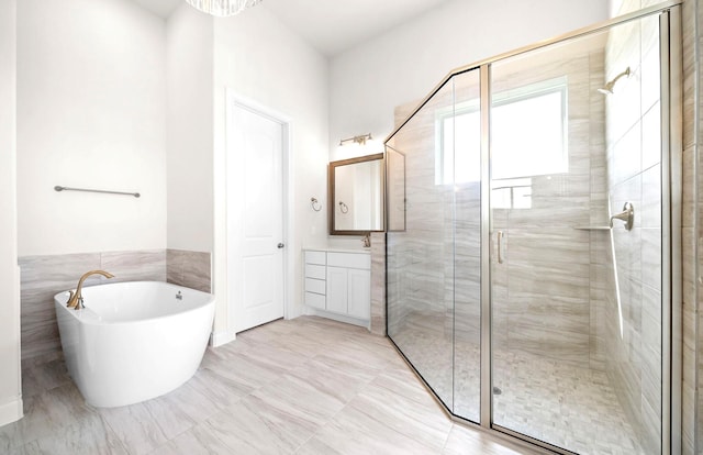 bathroom with a freestanding tub, vanity, and a stall shower