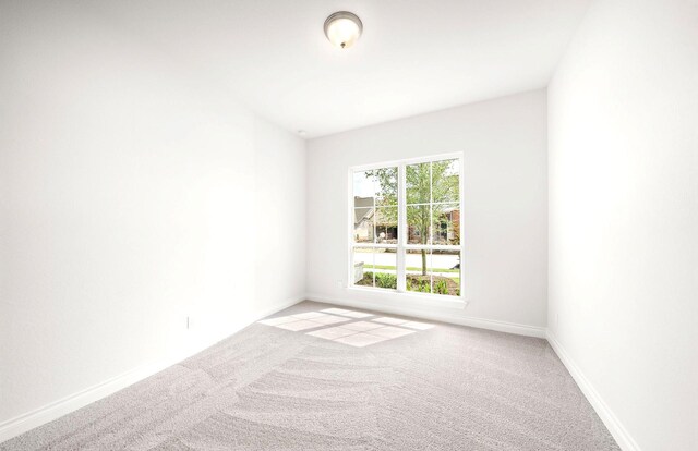 empty room with baseboards and light carpet