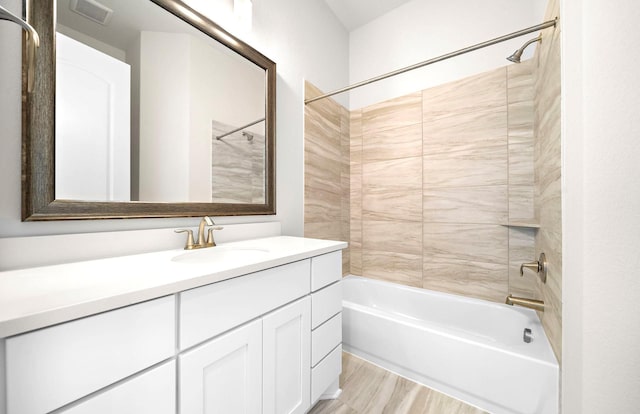 bathroom with wood finished floors, visible vents, shower / bathing tub combination, and vanity